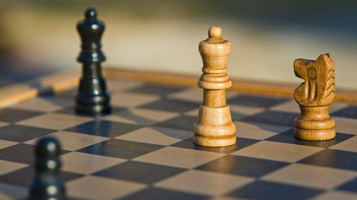 Chess pieces set up on a wooden board