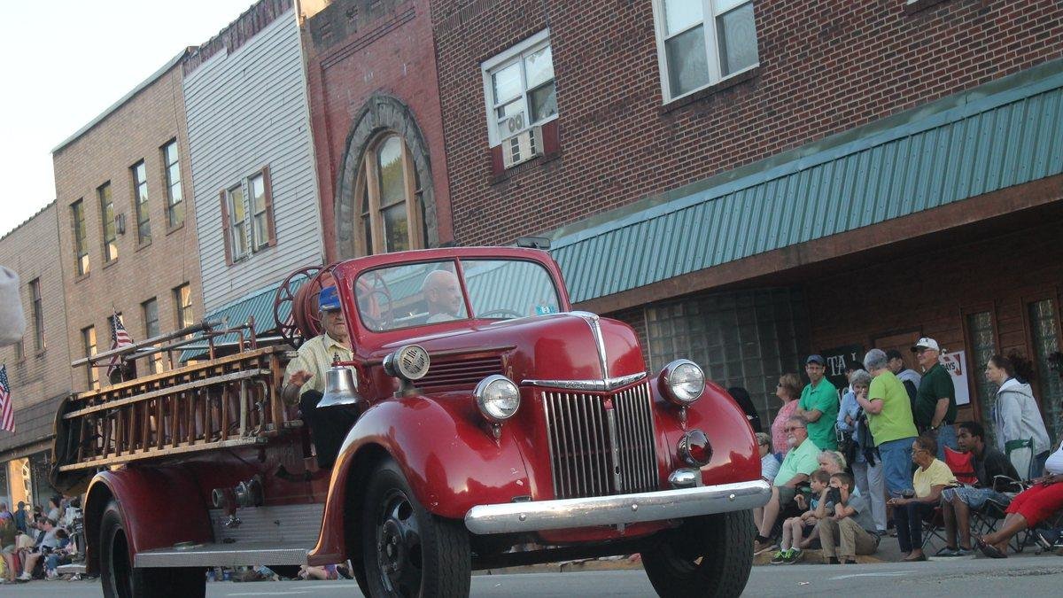 Vintage red fire truck rolling down a small town parade route