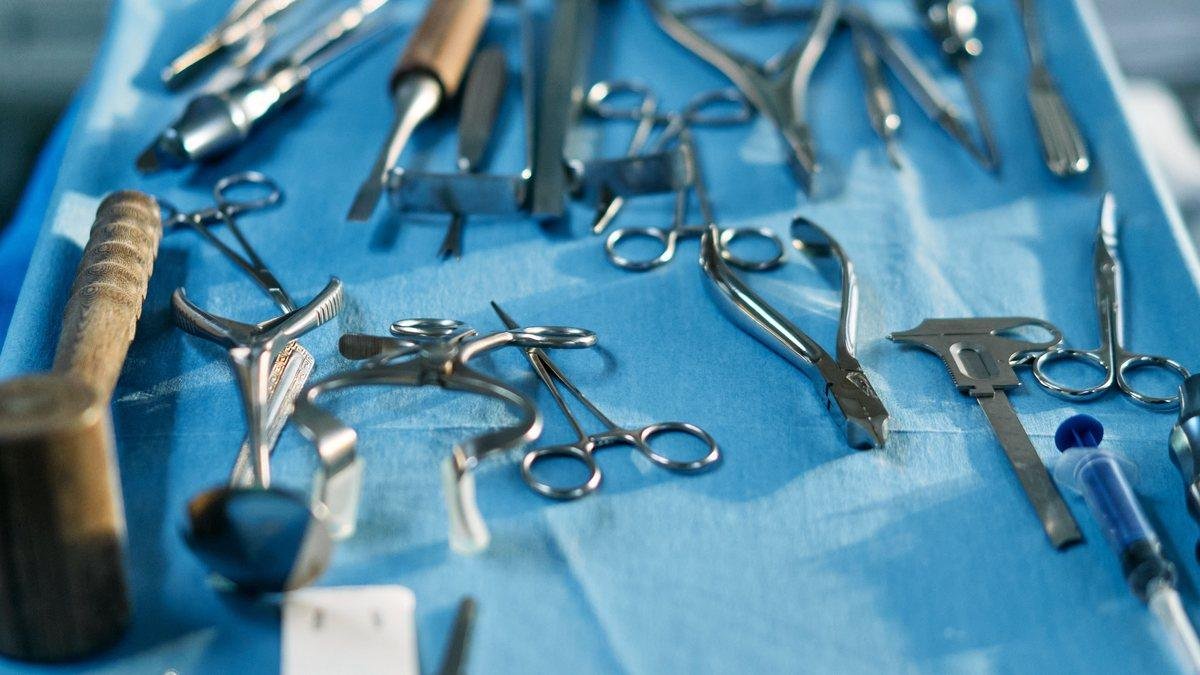 Surgical instruments laid out on a blue drape