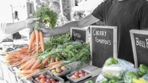 Vegetable stand with carrots and tomatoes at a farmers market