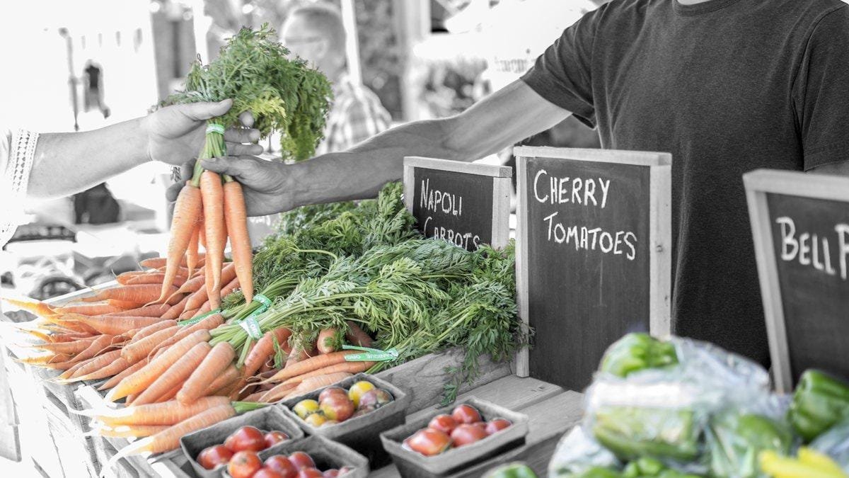Vegetable stand with carrots and tomatoes at a farmers market