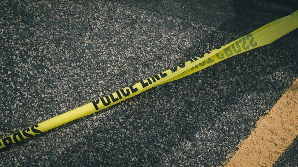 Yellow and black police line tape stretched across a scene