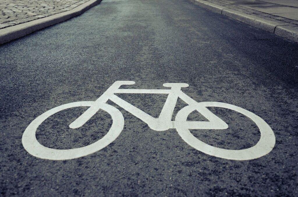 Close-up of a bicycle lane symbol painted on urban asphalt road surface.